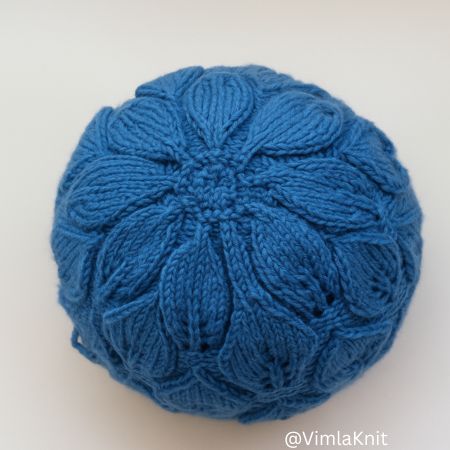 Top view of a blue leaf lace hat knitting pattern crown, showing leaf decreases and textured stitches.