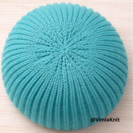 Top-down view of a teal blue knitted beanie crown showing symmetrical decreases and ribbed texture in a 1-row pattern by @VimlaKnit.