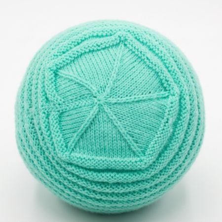 Kids beanie crown shaping showing neat knitted decreases and top view of handmade hat.