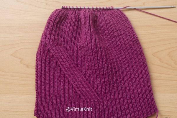 Purple ribbed knit beanie hat on single pointed needles showing crown shaping decreases, 2X2 rib stitch texture, knitting in progress by VimlaKnit.