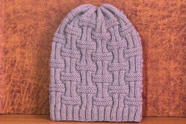 Easy double basket rib stitch unisex beanie in light gray yarn, knitted with beautiful basketweave cable pattern. Beginner friendly knitting pattern tutorial by Vimla Negi. Handmade cozy winter hat with ribbed brim and textured design.