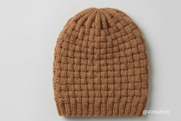 Handknit basketweave beanie in camel yarn with ribbed brim, front view.
