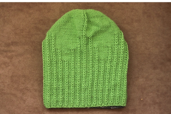 Green knit beanie with rib and garter stitch pattern, easy beanie knitting pattern for beginners.